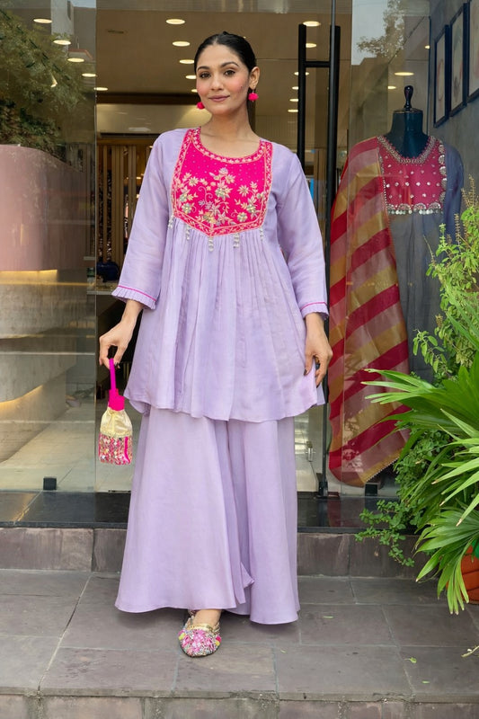 Floral embroidery, fine zari work, and pearl tassels for a rich festive look.